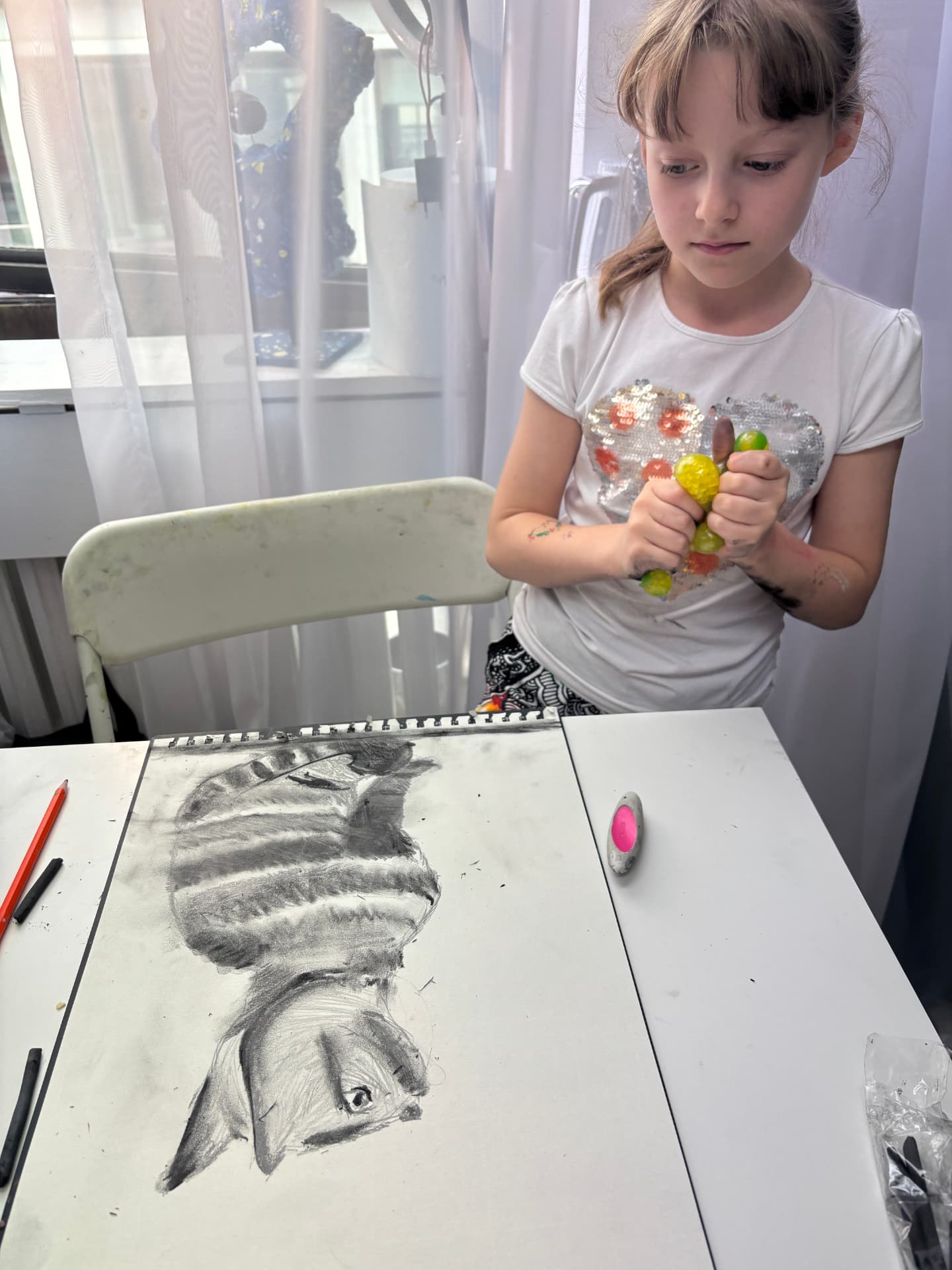 Dziewczynka przy rysunku węglem — portret kota